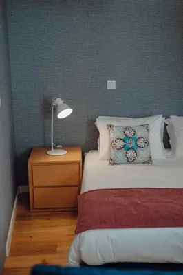 a bedroom with a bed with a lamp on a night stand at River Eyes at Porto apartments in Porto