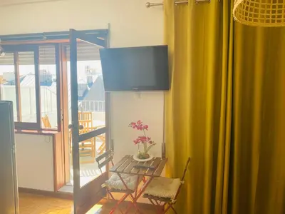 a room with a television and a chair and a window at Apartamento com patio na rua principal da cidade in Porto