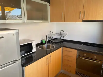a small kitchen with a sink and a microwave at Apartamento com patio na rua principal da cidade in Porto