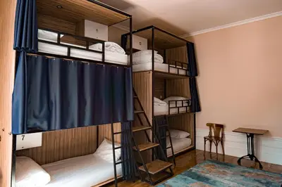 a room with bunk beds with a blue curtain at Rosalma Hostel in Porto