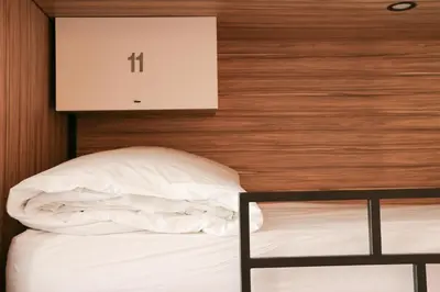 a bed in a room with a sign on the wall at Rosalma Hostel in Porto