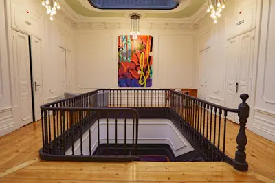 a staircase in a room with a painting on the wall at Rosalma Hostel in Porto