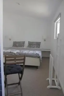 a room with a bed and a chair and a desk at Rosalma Hostel in Porto