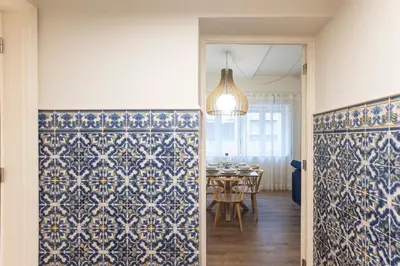 a dining room with blue and white tiles on the walls at Tasteful 2BR Flat in Art District by LovelyStay in Porto