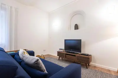 a living room with a blue couch and a flat screen tv at Tasteful 2BR Flat in Art District by LovelyStay in Porto