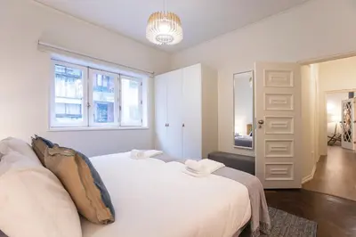 a bedroom with a large white bed and a window at Tasteful 2BR Flat in Art District by LovelyStay in Porto