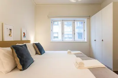 a bedroom with a large white bed with a window at Tasteful 2BR Flat in Art District by LovelyStay in Porto