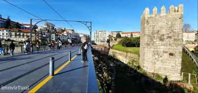 a person riding a skateboard down a street next to a castle at Dom Luis apartment in Porto