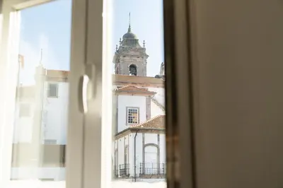 a view of a building with a clock tower from a window at Ribeira Loft in Porto