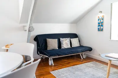 a blue couch in a white room with a table at Ribeira Loft in Porto