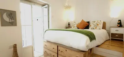 a bedroom with a large bed and a window at Flores'Old Town - Elegant studio with roomy patio in Porto