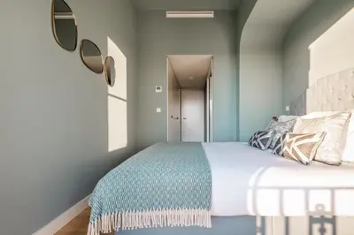 a bedroom with a bed with blue walls at Liberty 119 • Luxurious 1BD in Porto's main Avenue in Porto