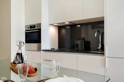 a kitchen with a glass table with wine glasses at Liberty 119 • Luxurious 1BD in Porto's main Avenue in Porto