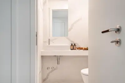 a white bathroom with a sink and a toilet at Liberty 119 • Luxurious 1BD in Porto's main Avenue in Porto