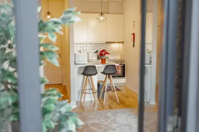 a kitchen with two stools in the middle of it at Apartamento Luminoso no Centro in Porto
