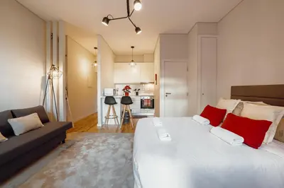 a bedroom with a large white bed with red pillows at Apartamento Luminoso no Centro in Porto