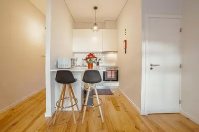a kitchen with two stools and a counter in a room at Apartamento Luminoso no Centro in Porto