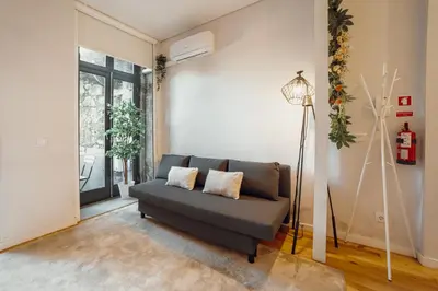 a living room with a couch and a lamp at Apartamento Luminoso no Centro in Porto