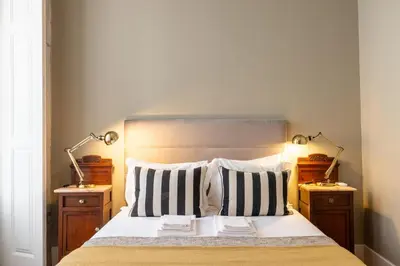 a bedroom with a bed with two lamps on two tables at Casa do Ofício - Livreiro in Porto