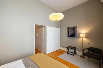 a bedroom with a bed and a chair and a lamp at Casa do Ofício - Livreiro in Porto