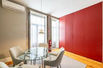 a dining room with a glass table and chairs at Casa do Ofício - Livreiro in Porto