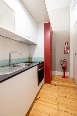a kitchen with white cabinets and a sink at Casa do Ofício - Livreiro in Porto