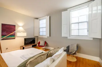a living room with a couch and a tv at Casa do Ofício - Livreiro in Porto