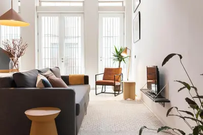 a living room with a couch and a tv at VIVA Miragaia Downtown in Porto