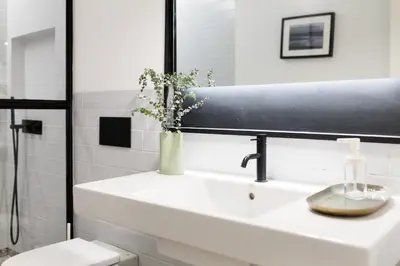 a bathroom with a sink with a vase of flowers on it at VIVA Miragaia Downtown in Porto
