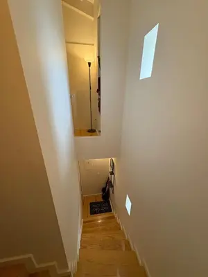 a stairway with a mirror and a cat sitting on the floor at GET a train and city view in Porto
