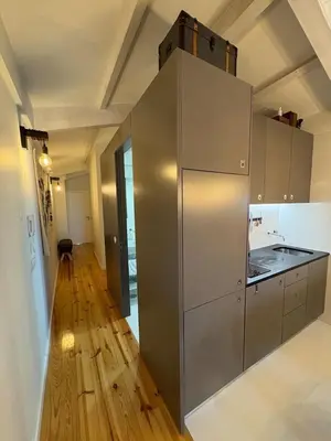 a kitchen with stainless steel appliances and a wooden floor at GET a train and city view in Porto