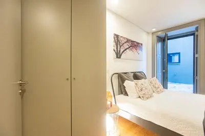 a bedroom with a bed and a sliding glass door at Downtown Studio w/ AC & Patio by LovelyStay in Porto