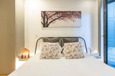 a bedroom with a white bed with two pillows at Downtown Studio w/ AC & Patio by LovelyStay in Porto