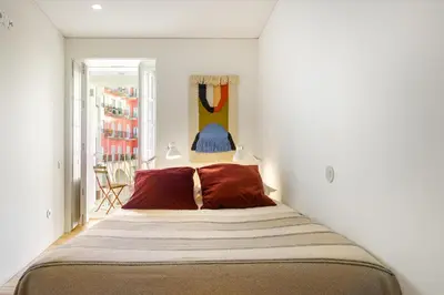 a bedroom with a large bed with red pillows at InBloom Apartments 2 in Porto