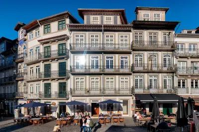 a large building with tables and umbrellas in front of it at InBloom Apartments 2 in Porto