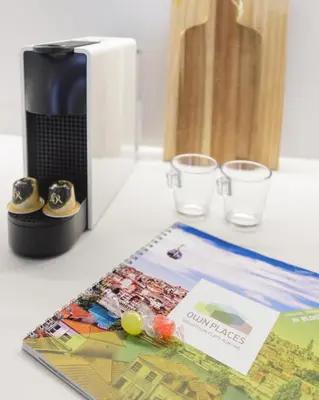 a table with a coffee maker and a map and two glasses at InBloom Apartments 3 in Porto