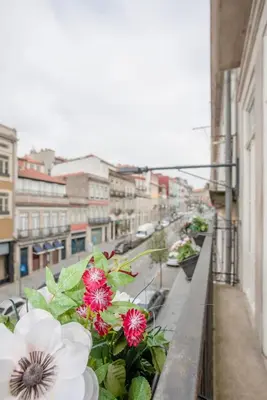 a balcony with flowers on the ledge of a building at Liiiving in Porto - Ribeira Secret Apartment in Porto