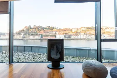 a tv in a room with a view of the water at MY DOURO VIEW Luxury Apartment River Front in Vila Nova de Gaia