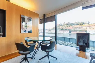 a dining room with a table and chairs and a large window at MY DOURO VIEW Luxury Apartment River Front in Vila Nova de Gaia