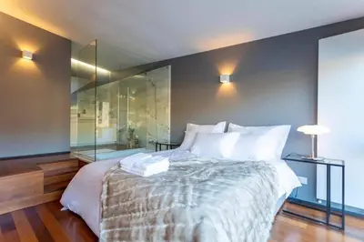 a bedroom with a large bed and a glass wall at MY DOURO VIEW Luxury Apartment River Front in Vila Nova de Gaia