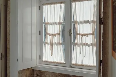 a window with white curtains in a room at River Eyes Apartments in Porto