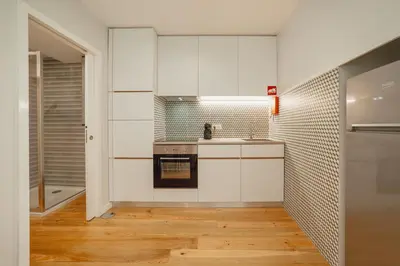 a kitchen with white cabinets and a sink at River Eyes Apartments in Porto