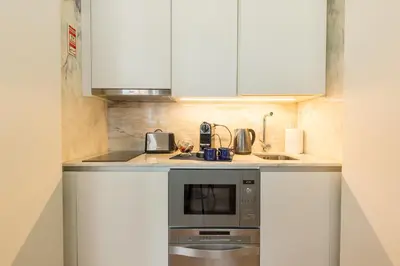 a small kitchen with white cabinets and a sink at In Between Exclusive Charm Apartment by the center in Porto