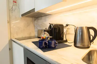 a kitchen counter with two coffee mugs and a toaster at In Between Exclusive Charm Apartment by the center in Porto