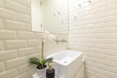 a white bathroom with a sink and a plant at In Between Exclusive Charm Apartment by the center in Porto
