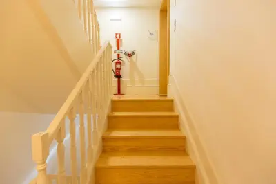a staircase with a red fire hydrant on the wall at In Between Exclusive Charm Apartment by the center in Porto