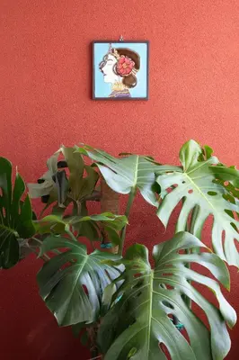 a plant in front of a red wall with a picture at Aconchegante Apartamento no Centro do Porto in Porto