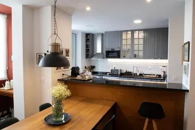 a kitchen with a wooden table with a vase of flowers at Aconchegante Apartamento no Centro do Porto in Porto