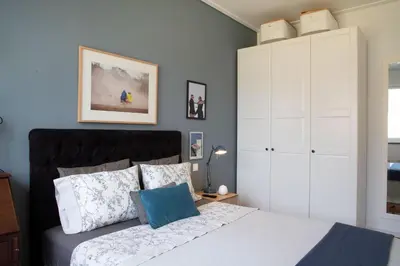 a bedroom with a bed and a large white cabinet at Aconchegante Apartamento no Centro do Porto in Porto