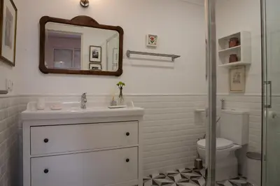 a bathroom with a sink and a toilet and a mirror at Aconchegante Apartamento no Centro do Porto in Porto